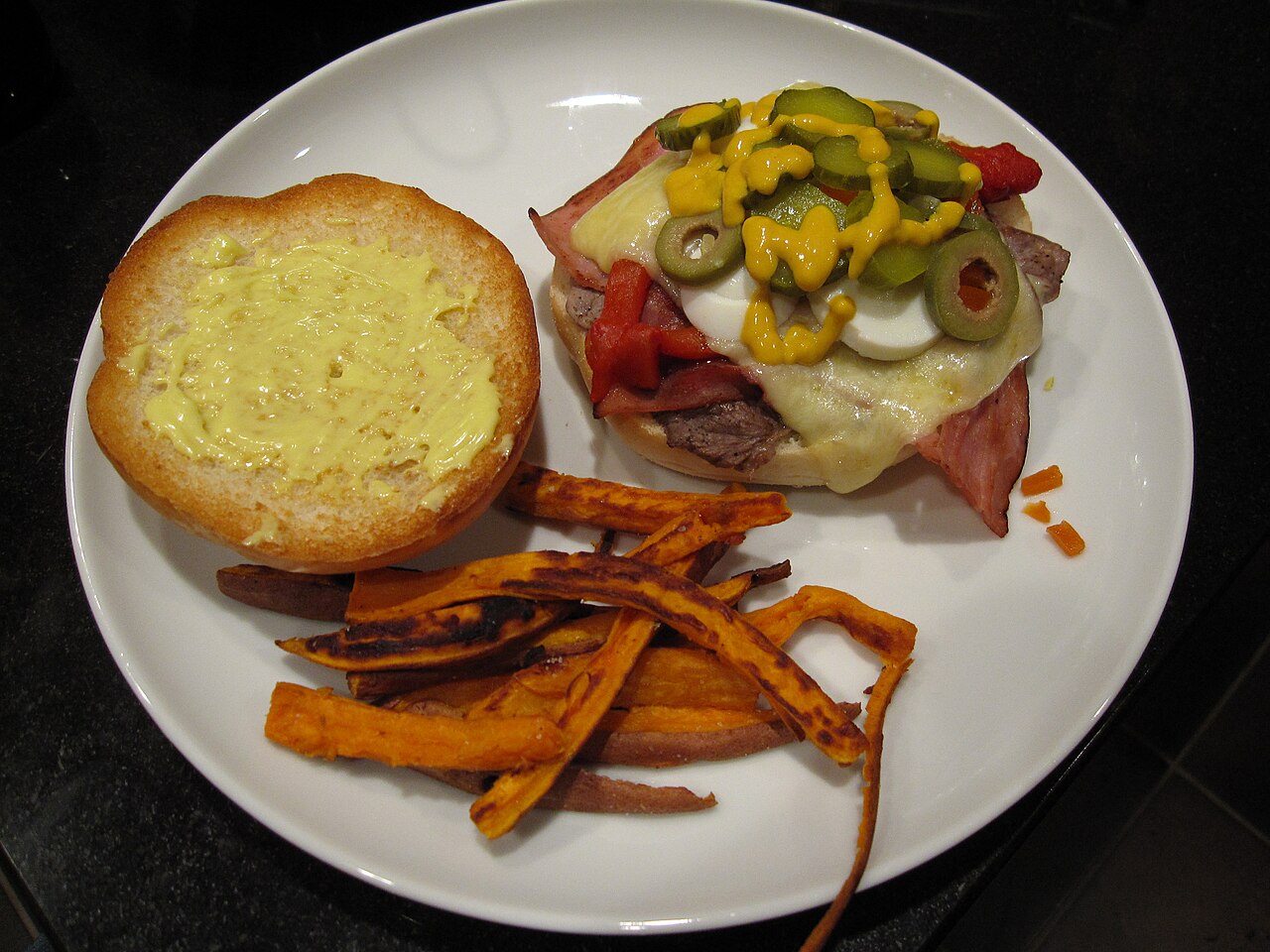 Chivito uruguayo al pan, servido con papas fritas